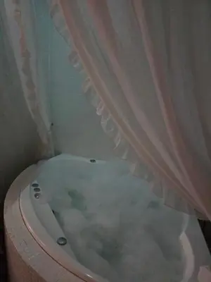 a bathroom with a bath tub with a curtain at Apartamentai su jacuzzi in Vilnius