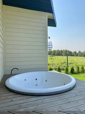 a large white tub sitting on a wooden deck at Sauna for celebration and leisure in Grygaytse
