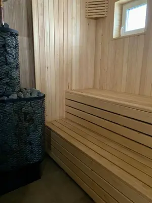 a wooden sauna with a bench and a window at Sauna for celebration and leisure in Grygaytse