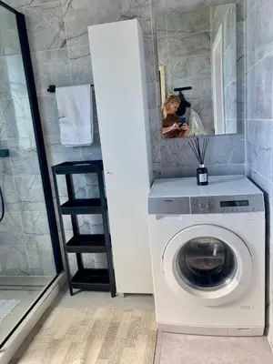 a washing machine in a bathroom with a mirror at Sauna for celebration and leisure in Grygaytse