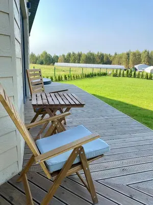 two chairs and a picnic table on a porch at Sauna for celebration and leisure in Grygaytse