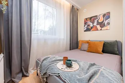 a small room with a bed and a table at Cozy flat in Antakalnis in Vilnius