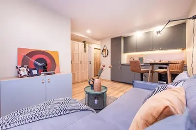 a living room with a bed and a kitchen at Cozy flat in Antakalnis in Vilnius