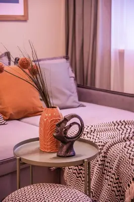 a table with a vase on it next to a bed at Cozy flat in Antakalnis in Vilnius