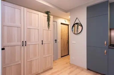 a hallway with wooden doors and a mirror at Cozy flat in Antakalnis in Vilnius