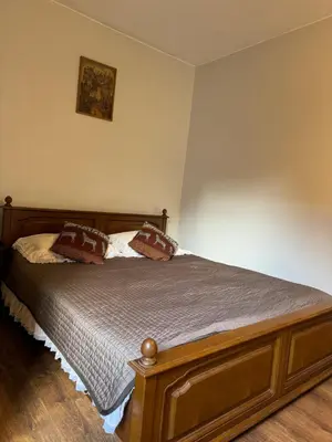 a bedroom with a wooden bed with pillows on it at Danarent Tilto in Vilnius