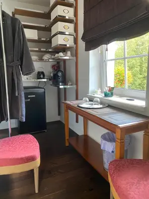 a kitchen with a wooden table and a window at Gulbės Apartamentai in Anykščiai