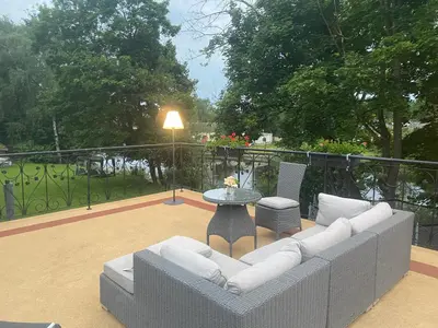 a living room with a couch and a table at Gulbės Apartamentai in Anykščiai
