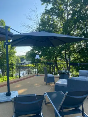 a patio with chairs and an umbrella and a table at Gulbės Apartamentai in Anykščiai