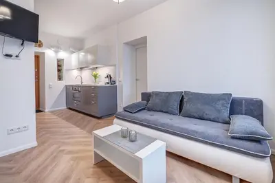 a living room with a blue couch and a kitchen at Angel House Vilnius, 47 in Vilnius