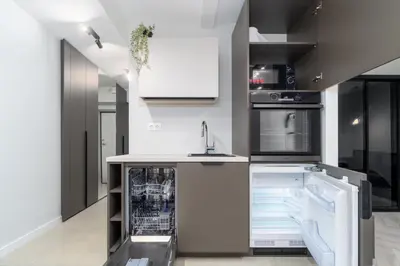 a kitchen with white cabinets and a dishwasher at Old Town Jacuzzi in Vilnius