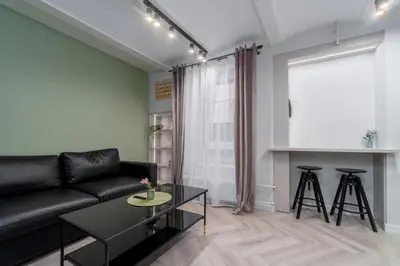 a living room with a black couch and a table at Old Town Jacuzzi in Vilnius
