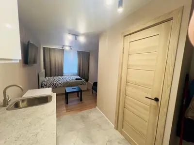 a bathroom with a door leading to a bedroom at studio apartment in Vilnius