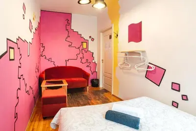 a room with two beds and a wall with a mural at Pogo Hostel in Vilnius