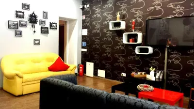 a living room with a yellow couch and a tv at Pogo Hostel in Vilnius