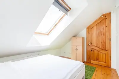 a attic bedroom with a bed and a skylight at Old town apartment with 3 bedrooms by URBAN RENT in Vilnius