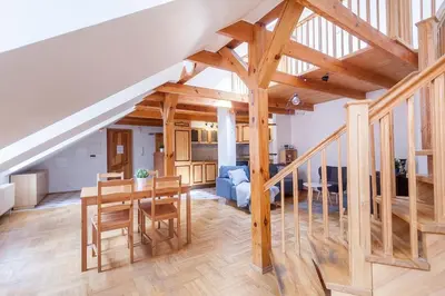 a large kitchen and living room with wooden beams at Old town apartment with 3 bedrooms by URBAN RENT in Vilnius