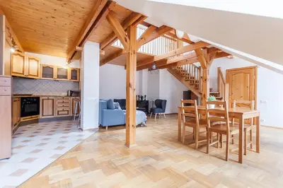 a kitchen and dining room with a wooden ceiling at Old town apartment with 3 bedrooms by URBAN RENT in Vilnius