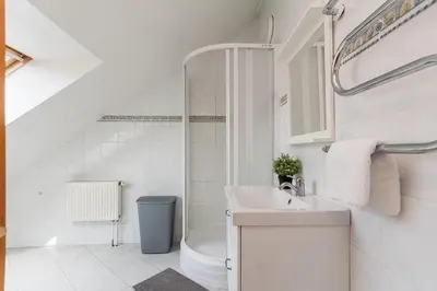 a white bathroom with a sink and a shower at Old town apartment with 3 bedrooms by URBAN RENT in Vilnius