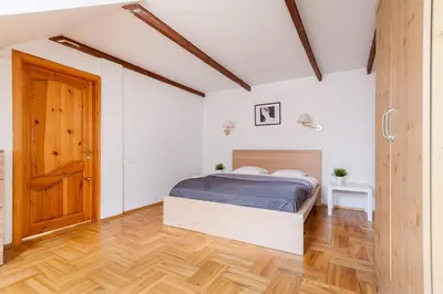 a bedroom with a bed and a wooden floor at Old town apartment with 3 bedrooms by URBAN RENT in Vilnius