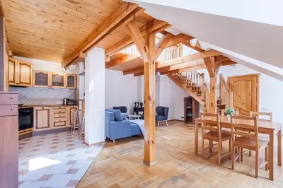 a kitchen and living room with a wooden ceiling at Old town apartment with 3 bedrooms by URBAN RENT in Vilnius
