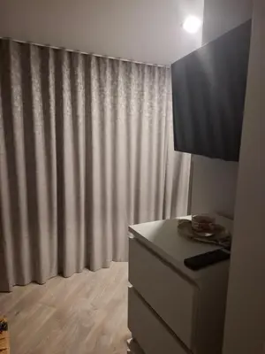 a room with a dresser and a curtain at Šermukšnis in Rokiškis
