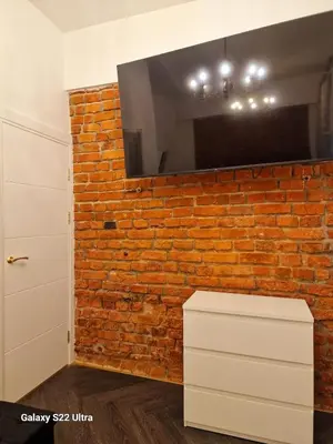 a brick wall with a television on top of it at Kaunas Studios - RentA 18 in Kaunas