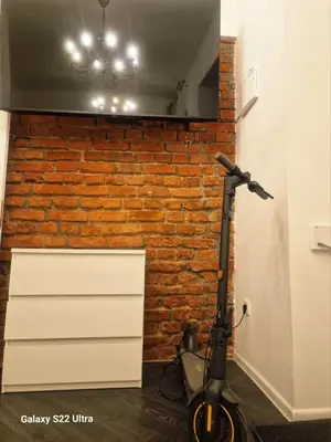 a scooter is parked next to a brick wall at Kaunas Studios - RentA 18 in Kaunas