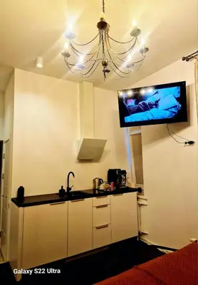 a kitchen with a flat screen tv hanging from the ceiling at Kaunas Studios - RentA 18 in Kaunas