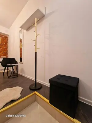 a room with a cross on the wall and a stool at Kaunas Studios - RentA 18 in Kaunas