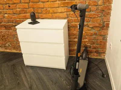 a vacuum against a brick wall next to a dresser at Kaunas Studios - RentA 19 in Kaunas