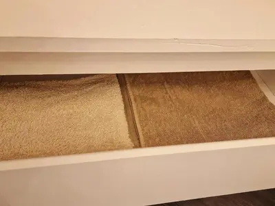 a drawer with two rugs underneath a desk at Kaunas Studios - RentA 19 in Kaunas