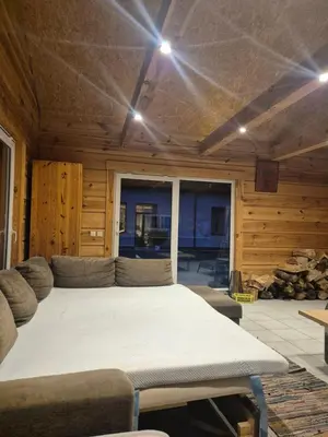 a large bed in a room with a couch at Tauro Pirtis in Vainiūnai