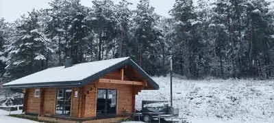 a small log cabin with snow on the roof at Tauro Pirtis in Vainiūnai