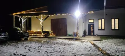 a house with christmas lights in a yard at night at Tauro Pirtis in Vainiūnai