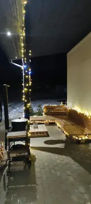 a room with a table and chairs and lights at Tauro Pirtis in Vainiūnai