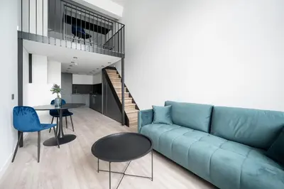 a living room with a blue couch and a table at Youston self check-in apartments Vilnius in Vilnius