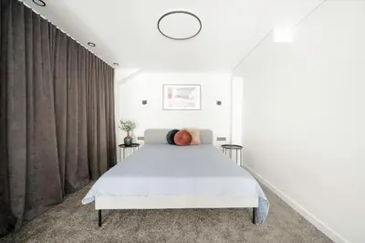 a bedroom with a bed and a large window at Youston self check-in apartments Vilnius in Vilnius