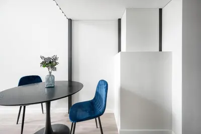 a dining room with a table and two blue chairs at Youston self check-in apartments Vilnius in Vilnius