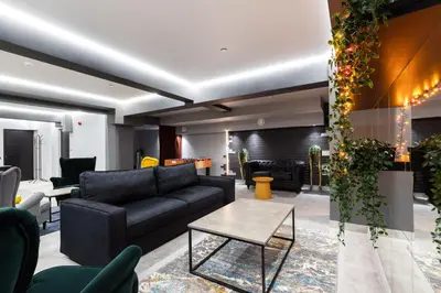 a living room with a black couch and a table at Youston self check-in apartments Vilnius in Vilnius