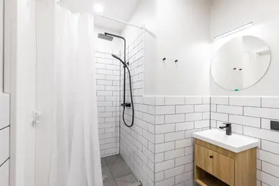 a white bathroom with a shower and a sink at Youston self check-in apartments Vilnius in Vilnius