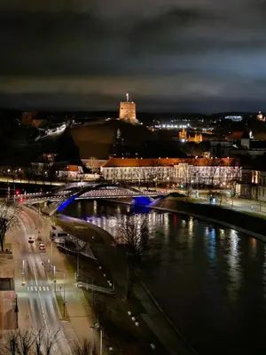 a bridge over a river with a city at night at Skyline Pearl Vilnius in Vilnius