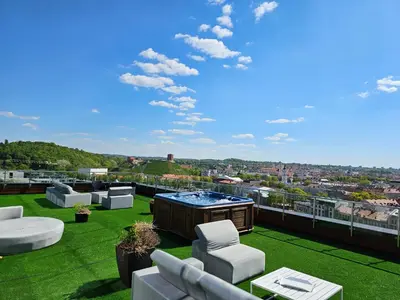 a patio with a hot tub on the roof of a building at Skyline Pearl Vilnius in Vilnius
