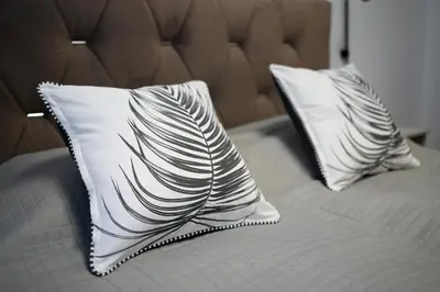 a bed with two white pillows on top of it at King Mindaugas center apartment in Kaunas