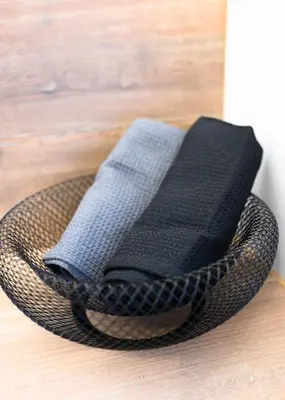 a basket with two napkins in it on a wooden floor at King Mindaugas center apartment in Kaunas