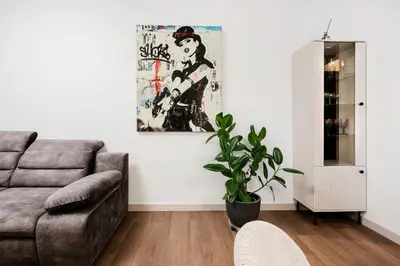a living room with a couch and a painting on the wall at King Mindaugas center apartment in Kaunas
