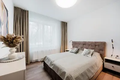 a bedroom with a bed and a large window at King Mindaugas center apartment in Kaunas