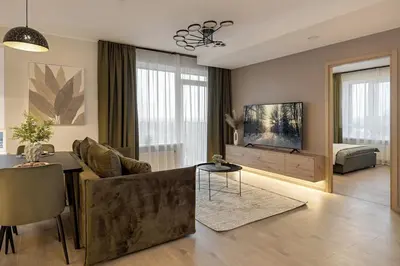 a living room with a couch and a television at Lake Town Apartment in Vilnius