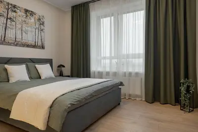 a bedroom with a bed and a large window at Lake Town Apartment in Vilnius