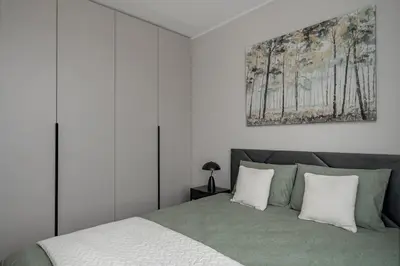 a bedroom with a bed and a painting on the wall at Lake Town Apartment in Vilnius